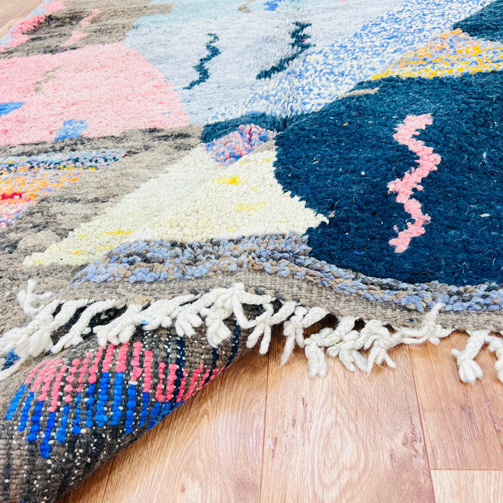 Colorful vintage Moroccan rug with intricate patterns, handwoven by Berber women using premium wool, vibrant fuchsia and sky blue.