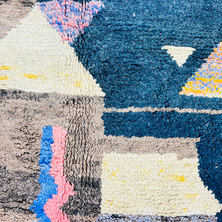 Close-up of Vintage Moroccan Rug with intricate wool patterns in blue, pink, mustard and ivory, showcasing traditional Berber craftsmanship.