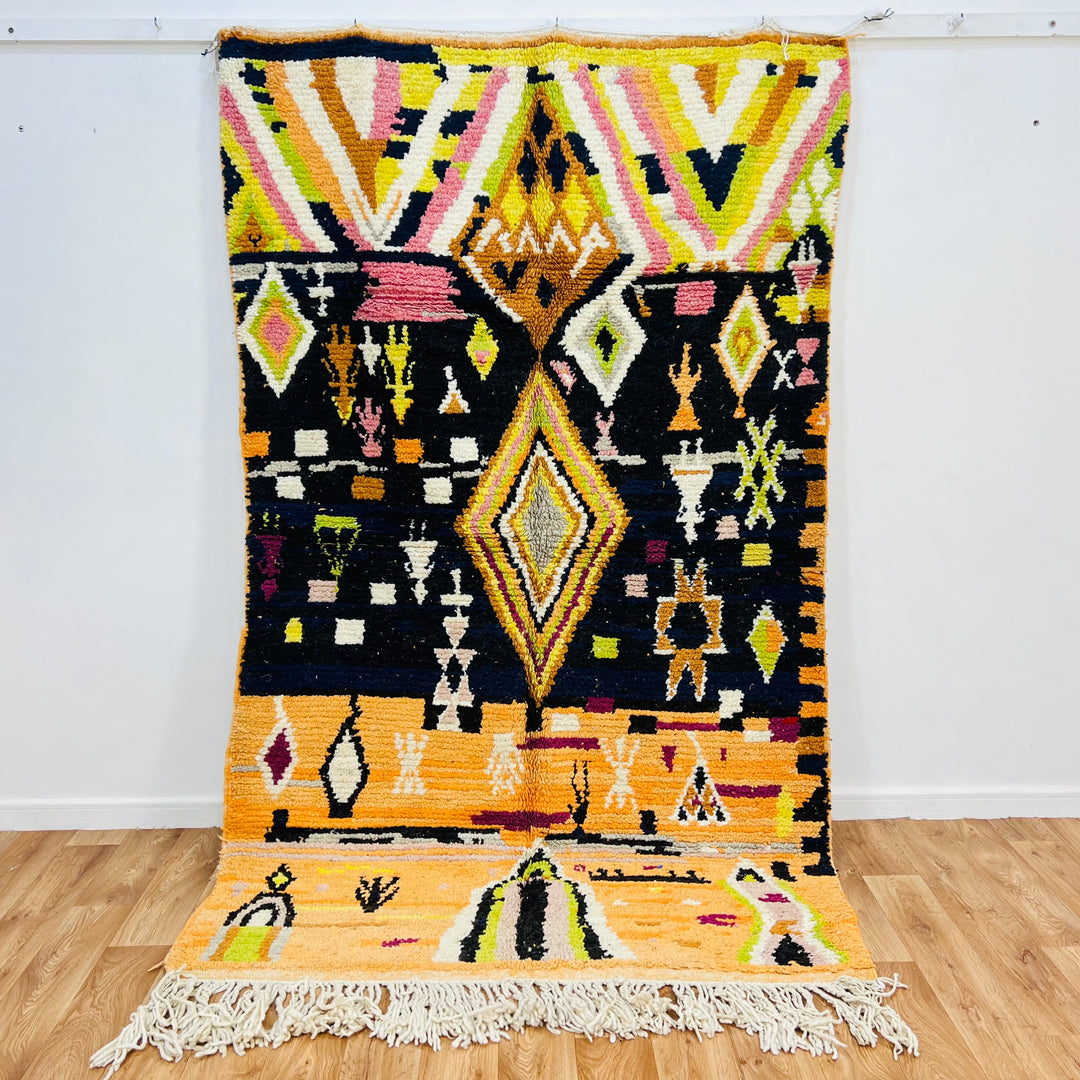 Handmade Moroccan wool rug featuring vibrant tribal design with diamond motifs, showcasing Amazigh craftsmanship.