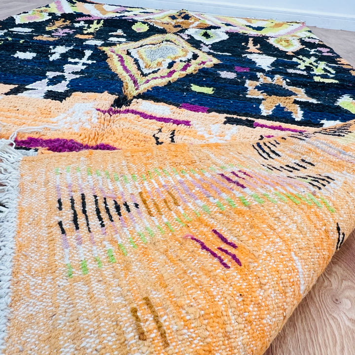 Diamond Tribal Moroccan Wool Rug - 278x151 cm, vibrant saffron, fuchsia, and black colors, handmade by Berber artisans.