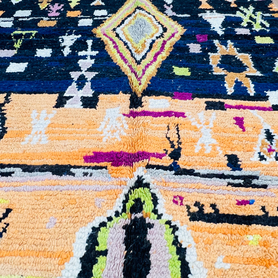 Handmade Moroccan wool rug with a diamond motif in orange, fuchsia, black, cream, and lime green. Traditional Berber design, 278x151 cm.