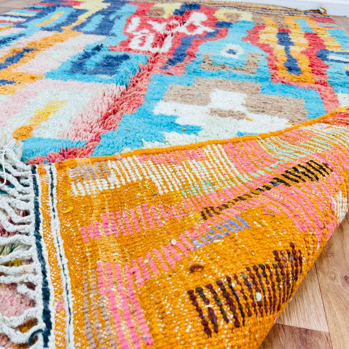 Bold geometric Moroccan wool rug with vibrant maze-like patterns in orange, blue, pink, 250×163 cm.