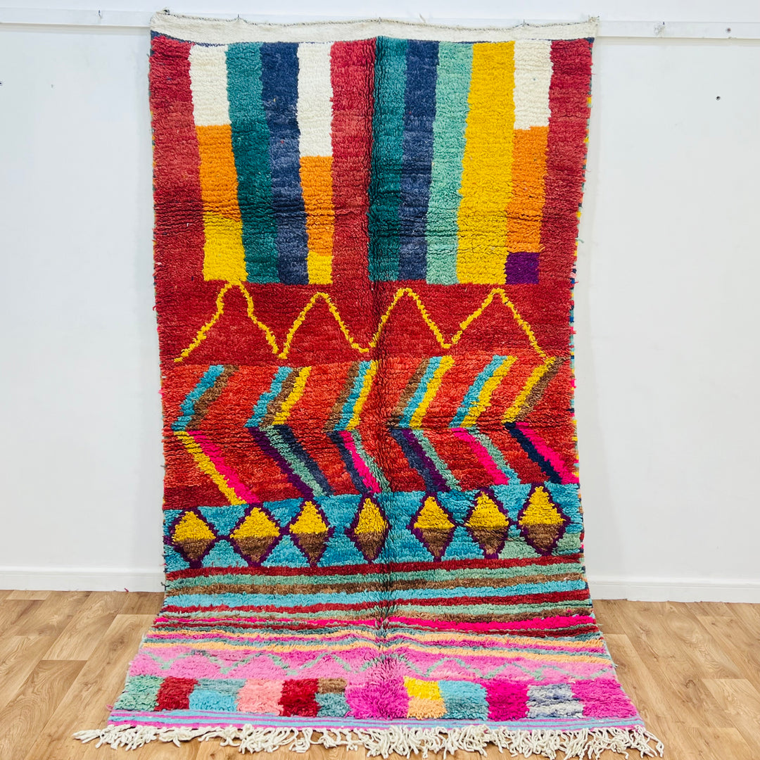 Bold colorful Moroccan Berber rug with geometric patterns in reds, yellows, blues. Handmade wool area rug, 9x4.9 ft.