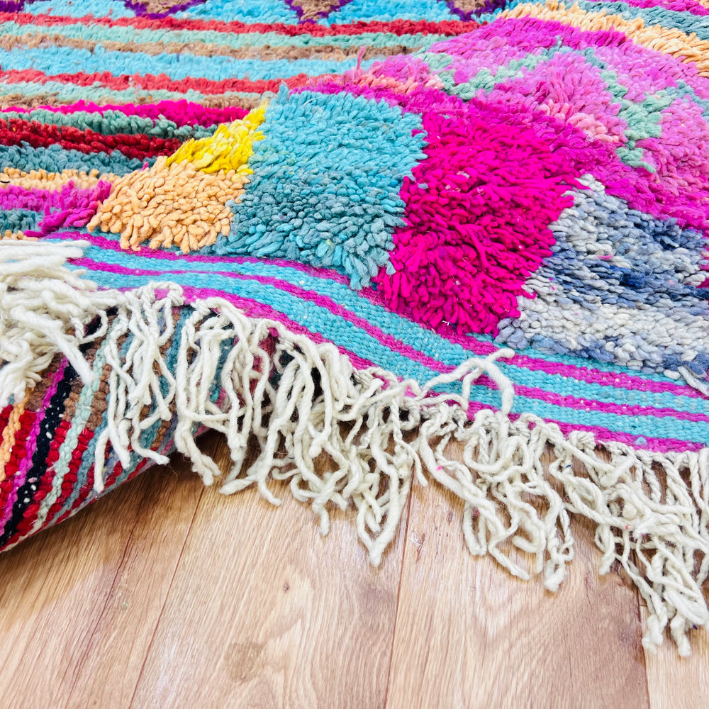 Colorful Moroccan Berber rug with geometric patterns and vibrant colors, handcrafted from wool. Perfect for adding bold energy to any space.