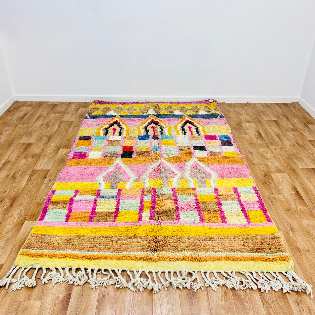 Colorful Moroccan wool rug with diamond and arch motifs, pink, yellow, orange tones. Handmade Berber tradition, 260 x 158 cm.