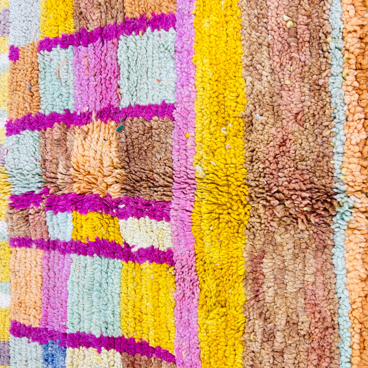 Colorful Moroccan wool rug with diamond and arch motifs in yellow, pink, orange; handmade Berber-style carpet.
