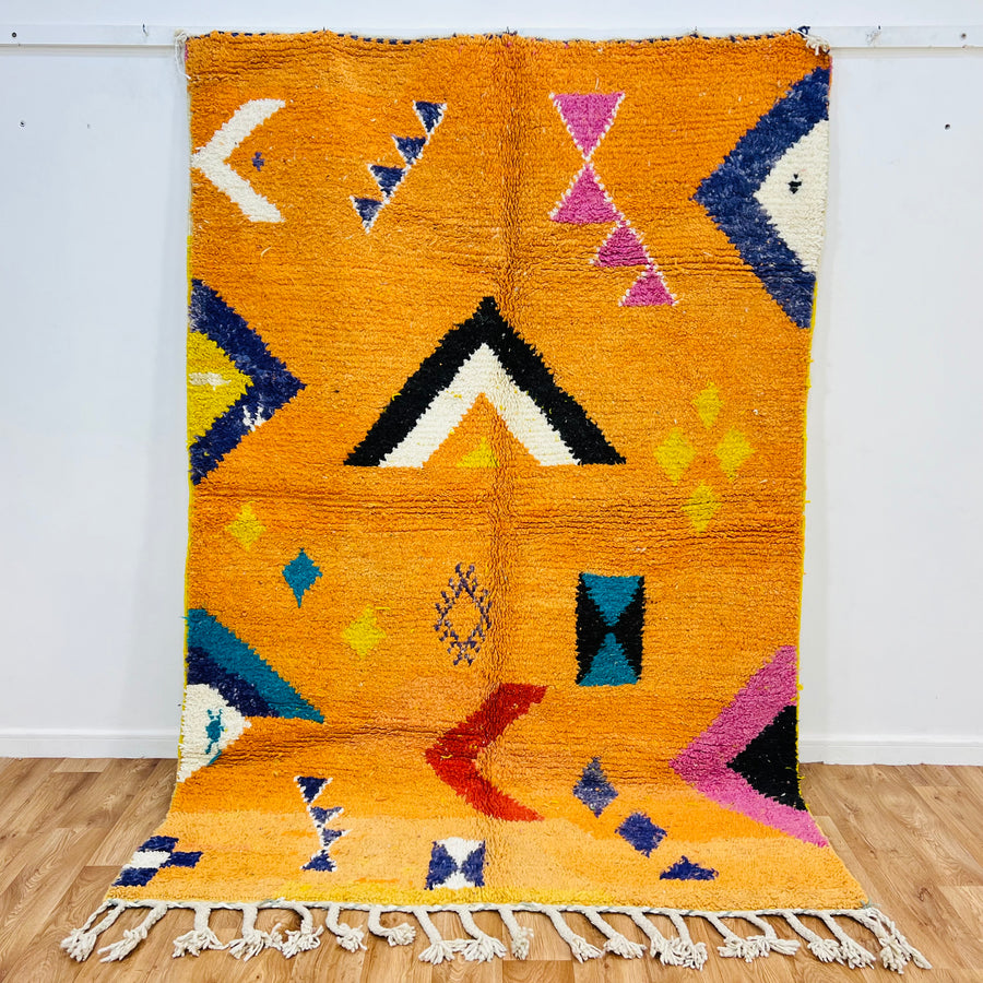 Orange Moroccan Wool Rug with Berber motifs, 246x167 cm, featuring geometric patterns in black, pink, blue, red, yellow, ivory.