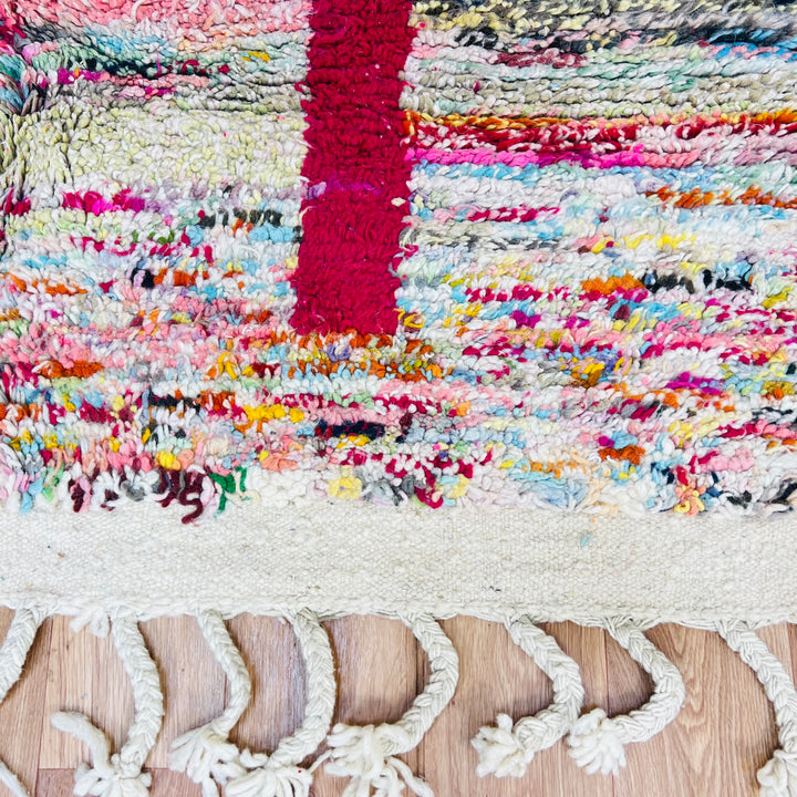 Colorful Moroccan Berber Wool Rug with abstract patterns and fringes, showcasing vibrant pink, blue, black, and green hues, 8x5ft.