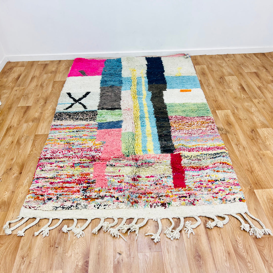 Colorful Moroccan Berber wool rug with abstract design in pink, blue, black, green, and cream, 8x5ft, handmade from natural wool.