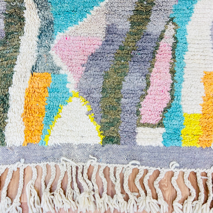 Colorful Moroccan wool rug with diamond patterns in orange, teal, yellow, and pink; traditional Berber design; 264x160 cm.