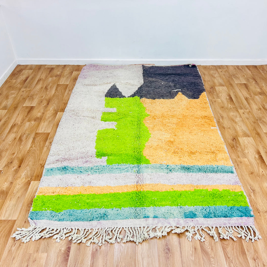 Color block Moroccan rug with geometric patterns in black, orange, lime green, and ivory tones. Handwoven wool rug 260 x 163 cm.