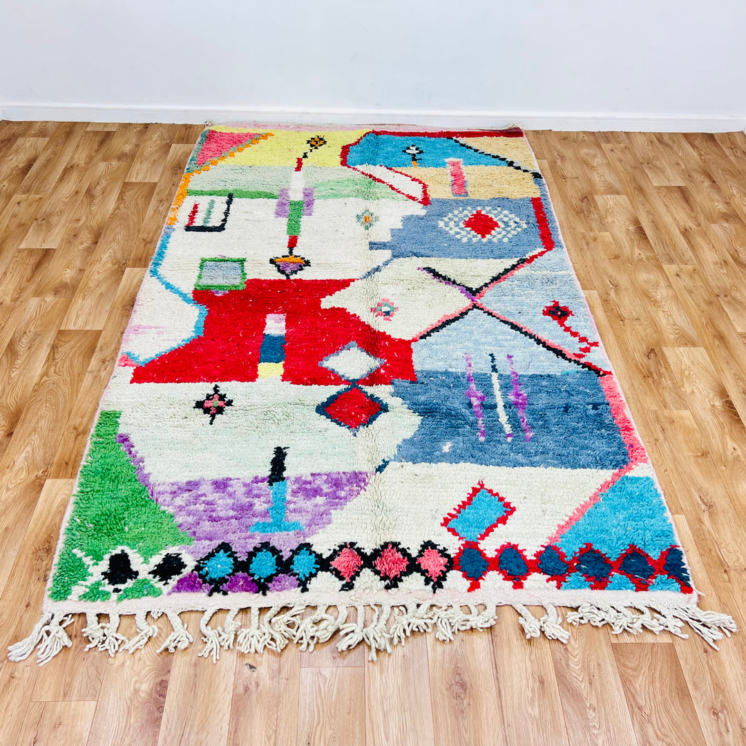 Handmade colorful Moroccan Berber rug 256x157 cm with geometric motifs, perfect for boho interiors. Available as a vibrant area rug.