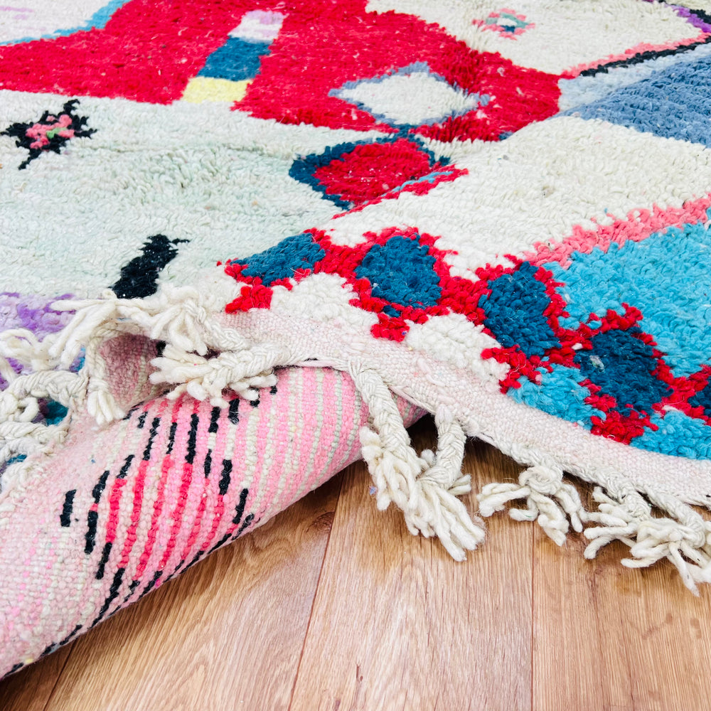 Colorful Moroccan Berber rug with geometric motifs and vibrant colors, handmade using traditional weaving techniques.