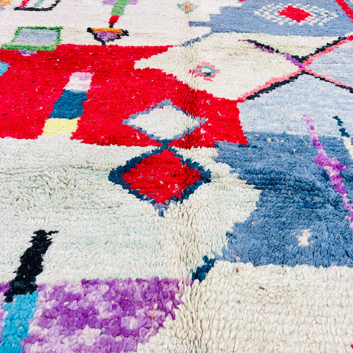 Colorful Moroccan Berber rug with geometric motifs in red, blue, green, and pastels, 256 x 157 cm. Ideal for boho spaces.