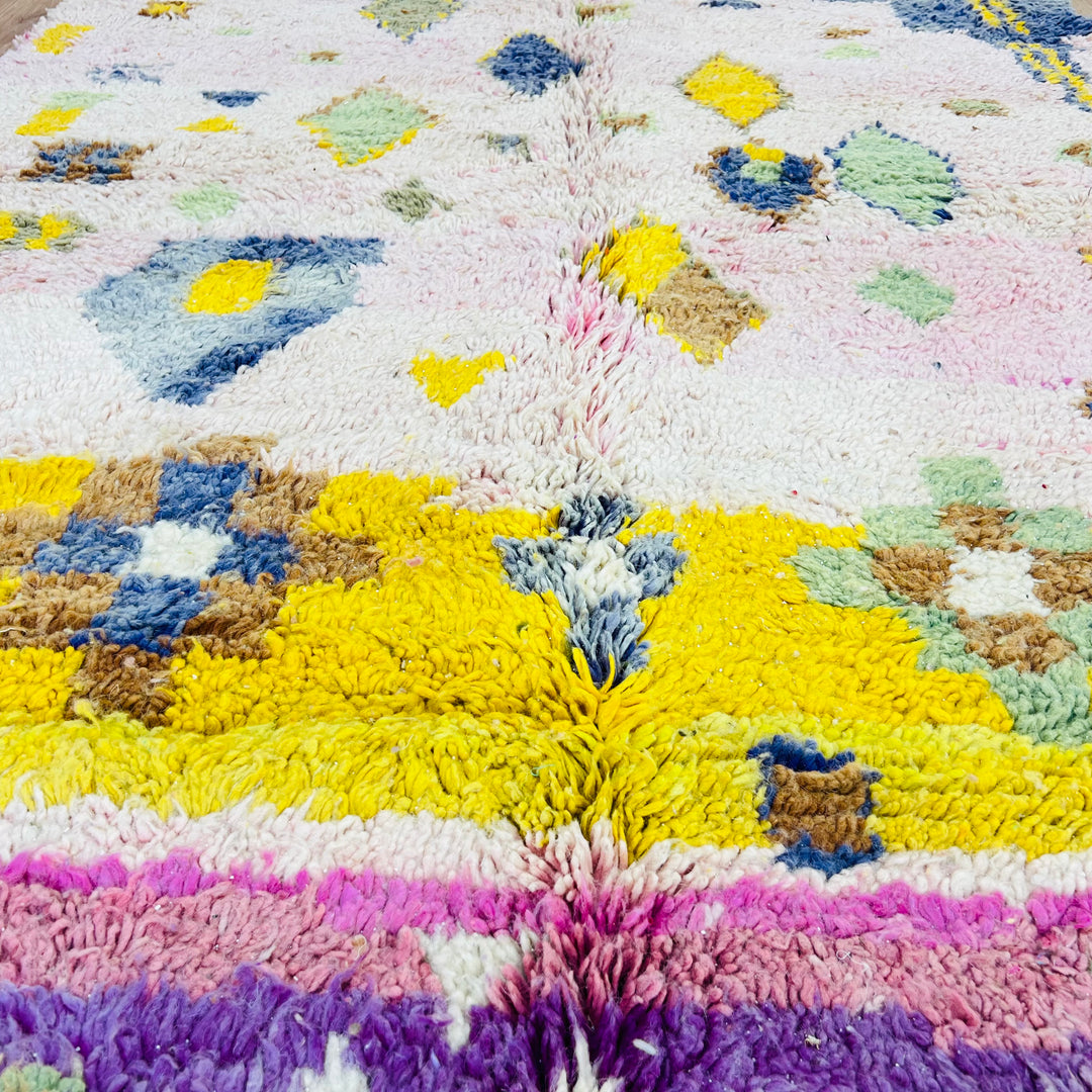 Handwoven pink and yellow vintage Moroccan rug with Berber symbols, showcasing bold character and traditional artistry.
