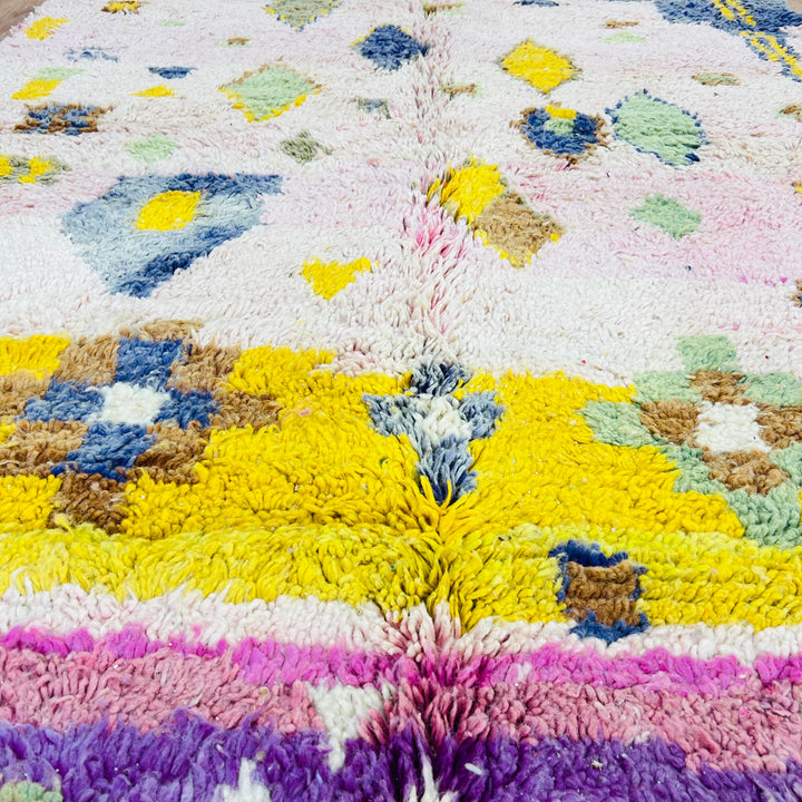 Handwoven pink and yellow vintage Moroccan rug with Berber symbols, showcasing bold character and traditional artistry.