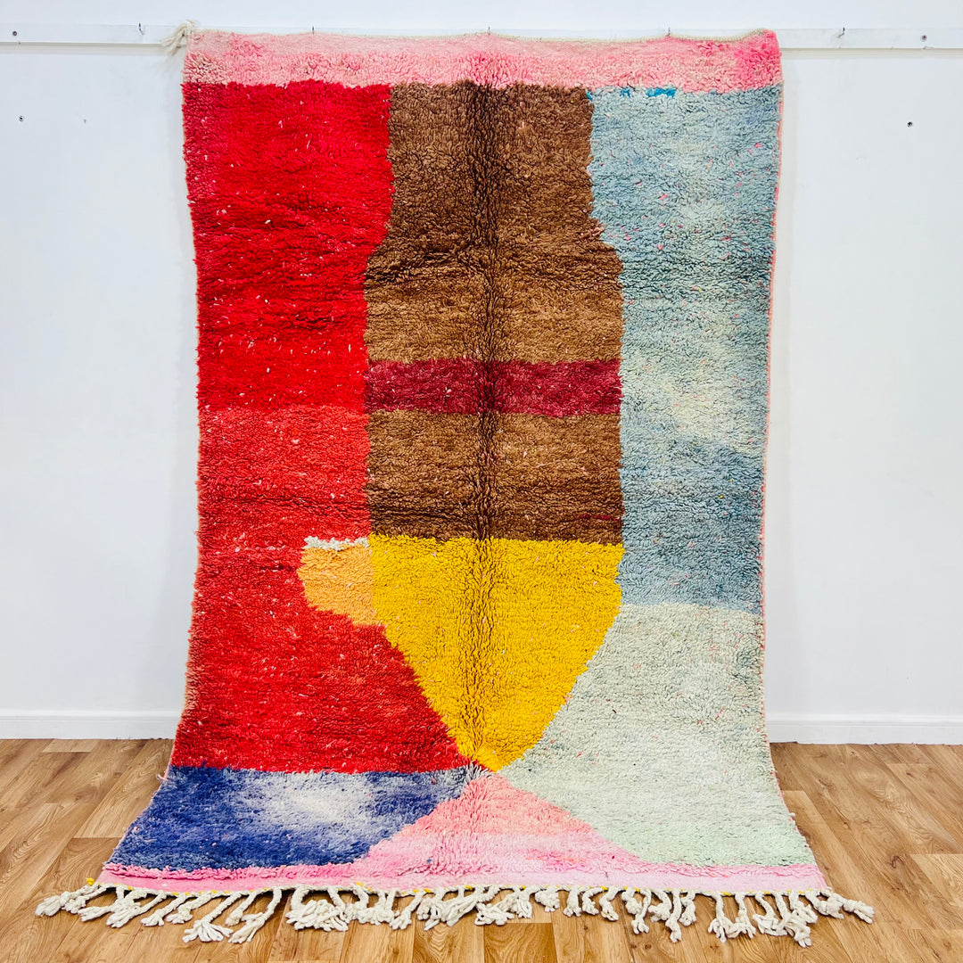 Colorful vintage Moroccan rug with geometric patterns in red, brown, yellow, and blue, handmade using wool. Unique cultural piece.