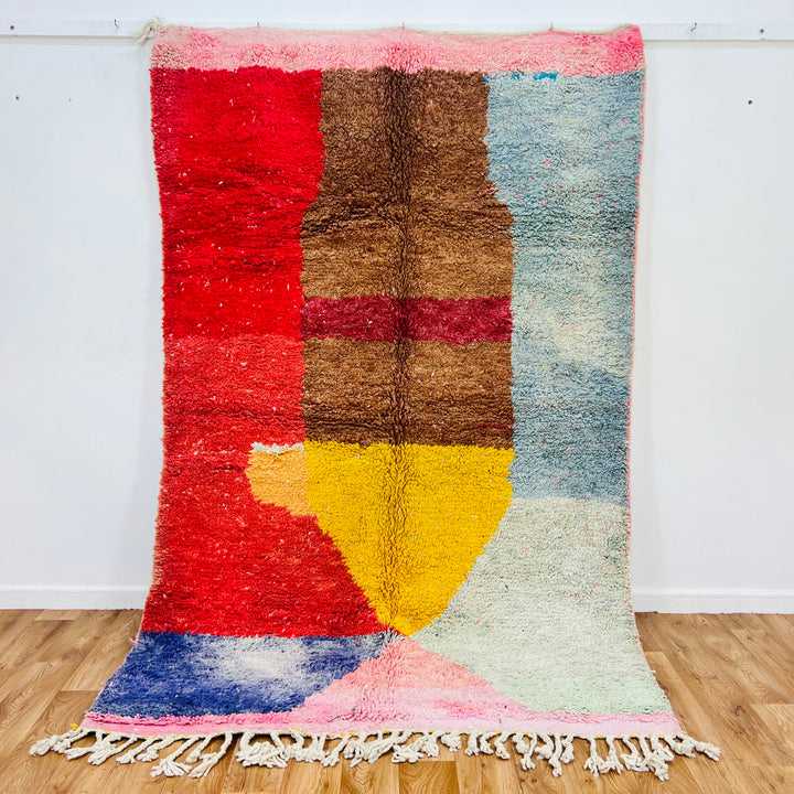 Colorful vintage Moroccan rug with geometric patterns in red, brown, yellow, and blue, handmade using wool. Unique cultural piece.