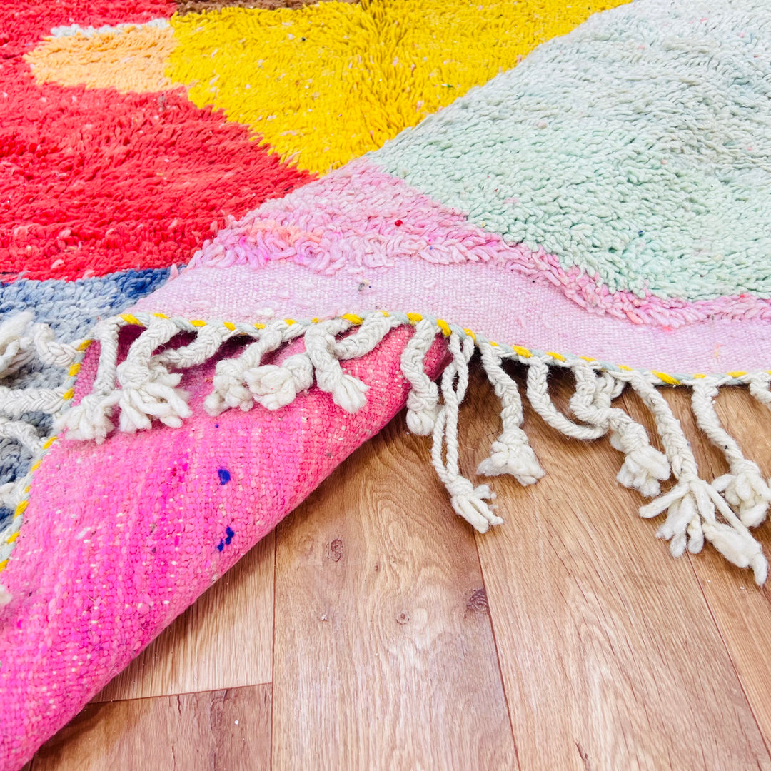 Pink Diamond Vintage Moroccan Rug with fringe, handmade by Berber women using 100% wool, featuring vibrant diamond patterns in pink, yellow, green.