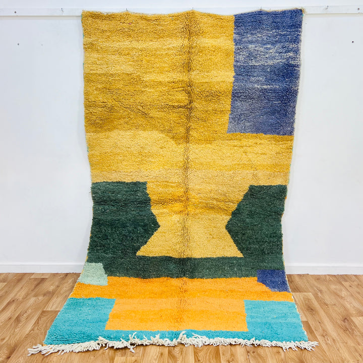 Yellow and green abstract Moroccan Berber rug, 8.8x5 ft, featuring geometric patterns with desert sunset colors in handmade wool.