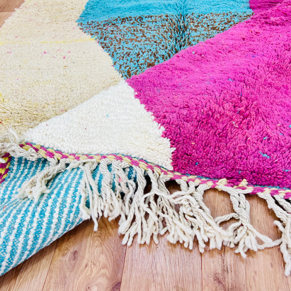 Pink and aqua abstract Moroccan wool rug with geometric patterns and fringe detail, showcasing vibrant Berber artistry.