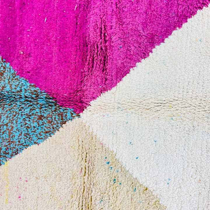 Pink and aqua Moroccan wool rug with abstract geometric pattern, featuring vibrant colors and traditional Berber design.