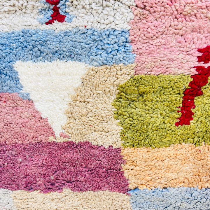 Vintage Moroccan wool rug with pink, blue, green patchwork, handwoven by artisans, Berber-inspired, 248x153 cm, bohemian style.