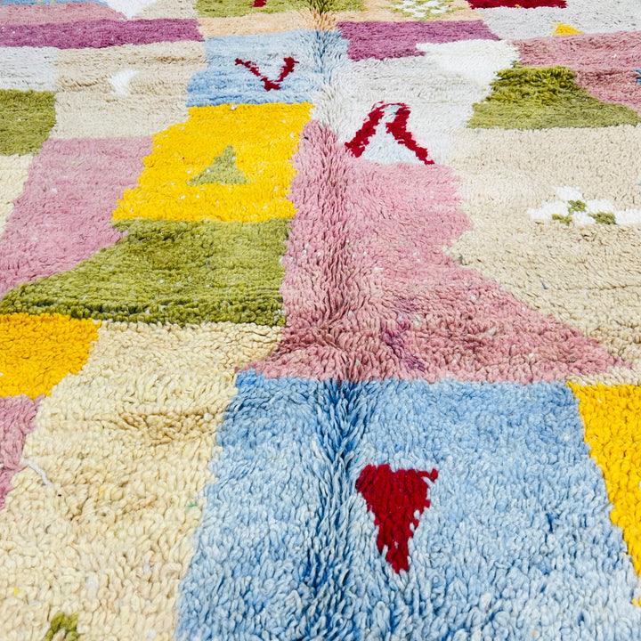 Colorful vintage Moroccan wool rug with patchwork design in pink, yellow, blue, and green. Handwoven Berber Moroccan rug.