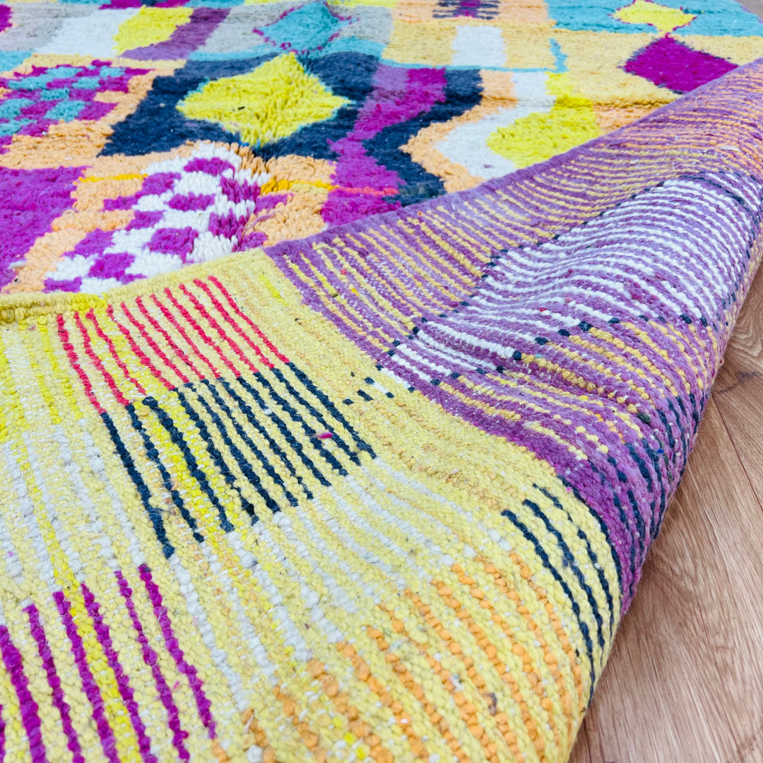 Colorful Beni Mrirt Moroccan rug with geometric motifs in pink, yellow, black, and teal, handmade from soft wool, 251 x 164 cm.