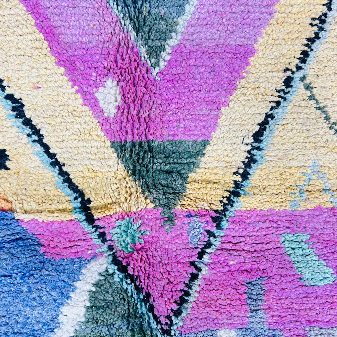 Colorful Moroccan wool rug with central pink diamond pattern and multicolored zigzags, handmade by Berber artisans.