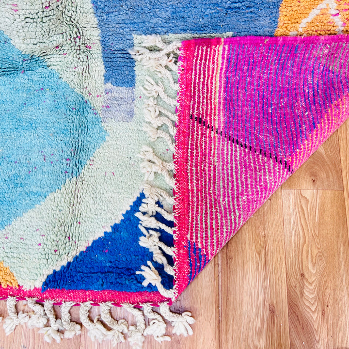 Colorful Moroccan Wool Rug with architectural motifs in pink, blue, and green, showcasing vibrant design and craftsmanship.