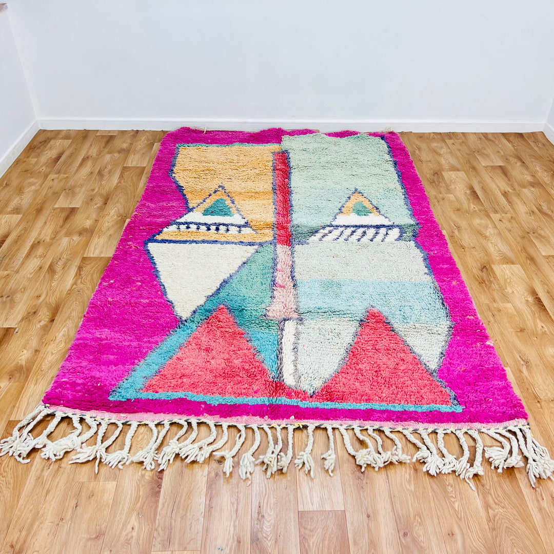Geometric Moroccan wool rug with pink border, peach and mint pyramids, navy accents, handwoven by Berber women, 8.4 x 5.5 ft.