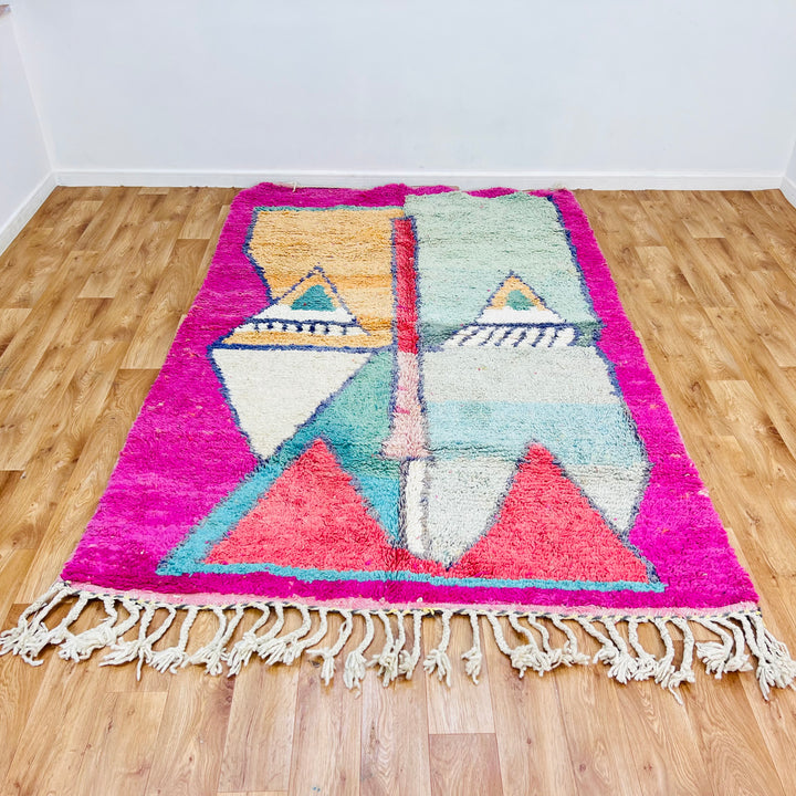 Geometric Moroccan wool rug with pink border, peach and mint pyramids, navy accents, handwoven by Berber women, 8.4 x 5.5 ft.