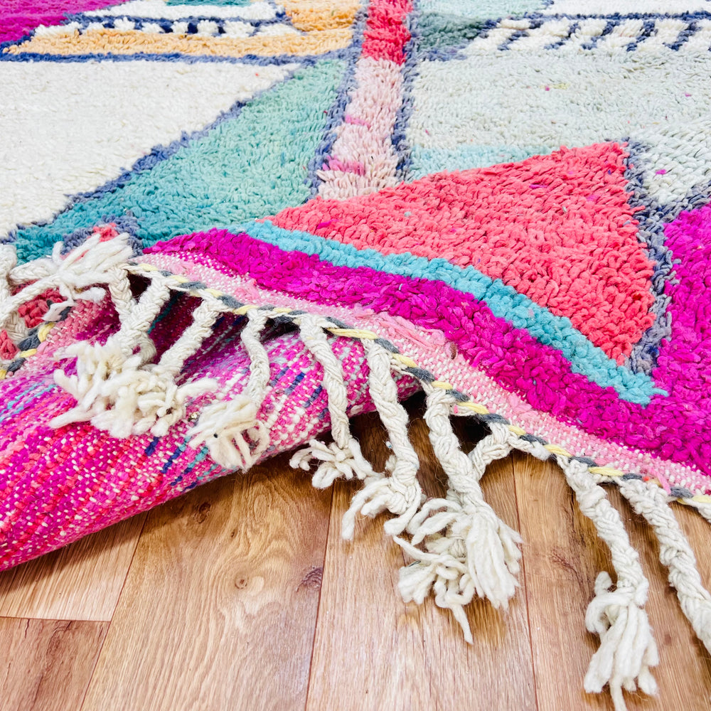 Geometric Moroccan wool rug in peach, mint, navy with fuchsia border, handwoven by Berber women, traditional knotting, 8.4 x 5.5 ft