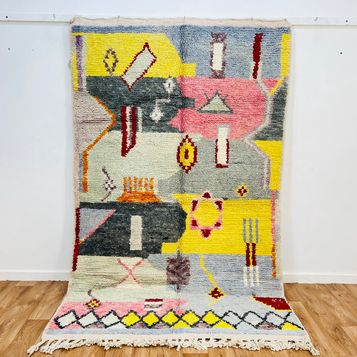 Colorful abstract Berber Moroccan wool rug with geometric shapes, sun motifs, and vibrant colors, handmade by artisans.