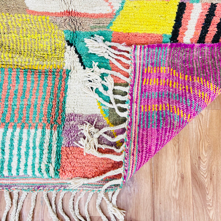 Colorful Patchwork Abstract Moroccan Wool Rug with geometric design and vibrant patterns in pink, yellow, turquoise, and earthy tones.