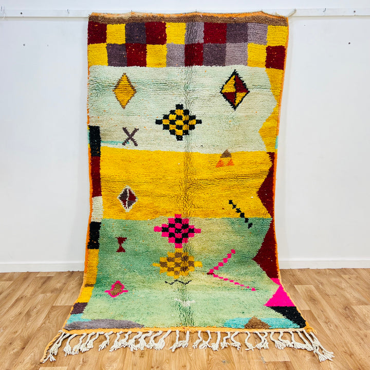 Playful Berber Moroccan Wool Rug with vibrant tribal symbols, 268x150 cm, featuring checkered borders and bold, colorful motifs.