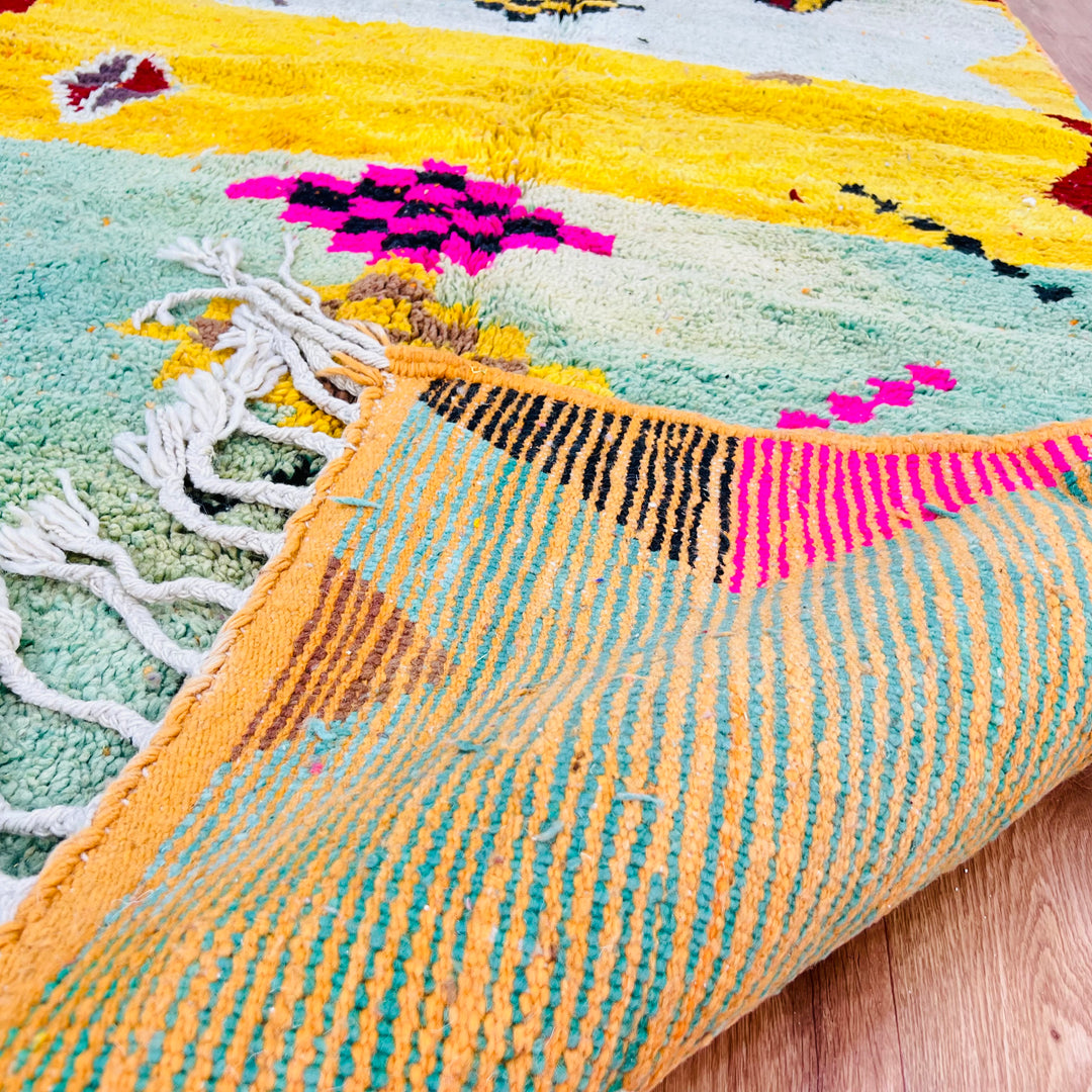 Playful Berber Moroccan wool rug with vibrant colors, tribal motifs, and fringed edges, 268x150 cm.