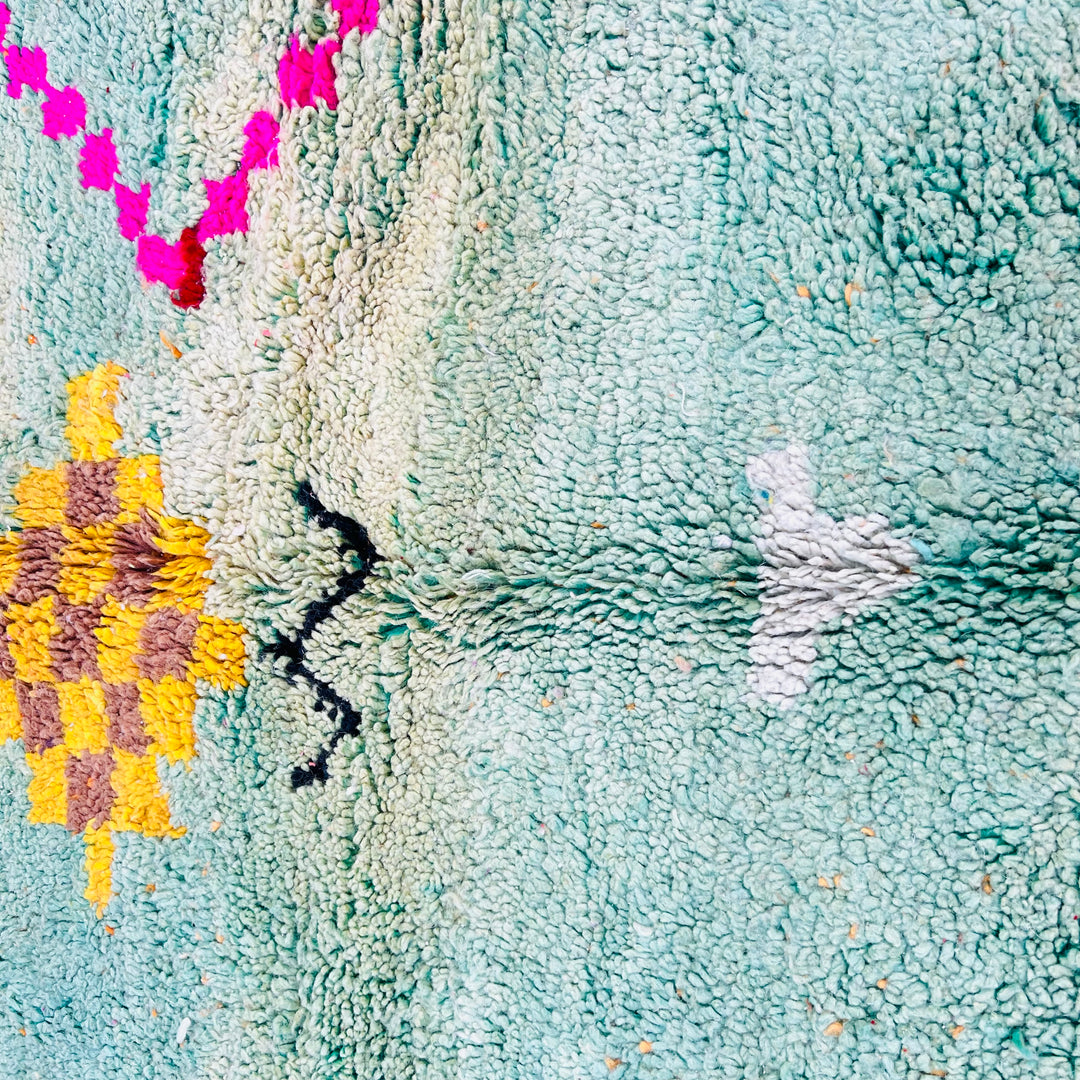 Close-up of playful Berber Moroccan wool rug with vibrant colors, tribal symbols, and abstract motifs. Handmade Moroccan rug.
