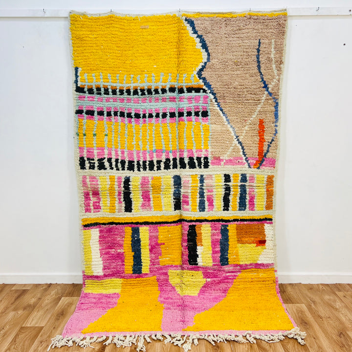 Striped Yellow Moroccan Wool Rug with pink, black, and beige patterns. Handmade by Berber artisans, 245x145 cm.