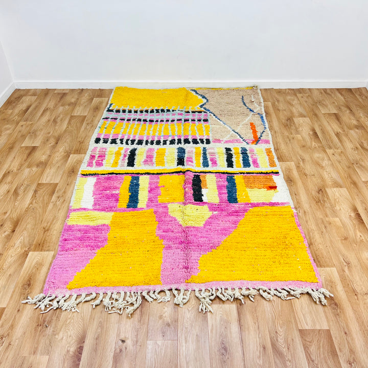 Striped Yellow Moroccan Wool Rug with pink, black, and orange accents, handmade by Berber artisans.