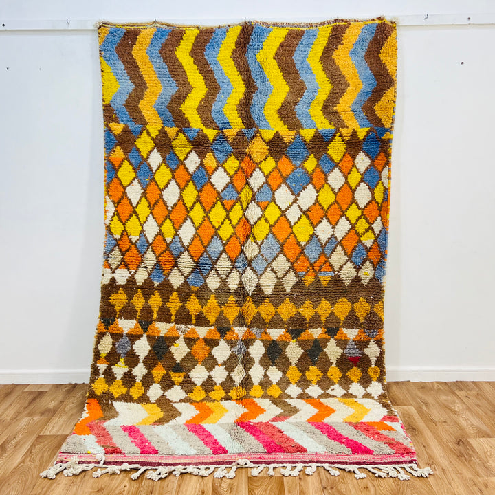 Handmade Moroccan wool rug with zigzag and diamond patterns, vibrant colors, 268x161 cm. Perfect traditional Moroccan decor.