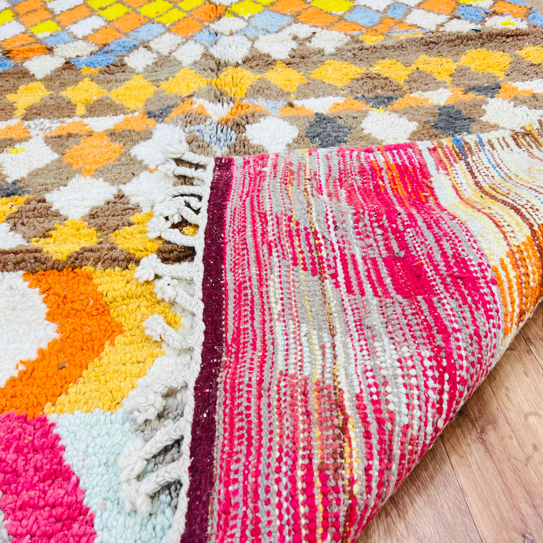 Handmade Moroccan wool rug with diamond and zigzag patterns in vibrant colors, showcasing traditional Berber artistry.