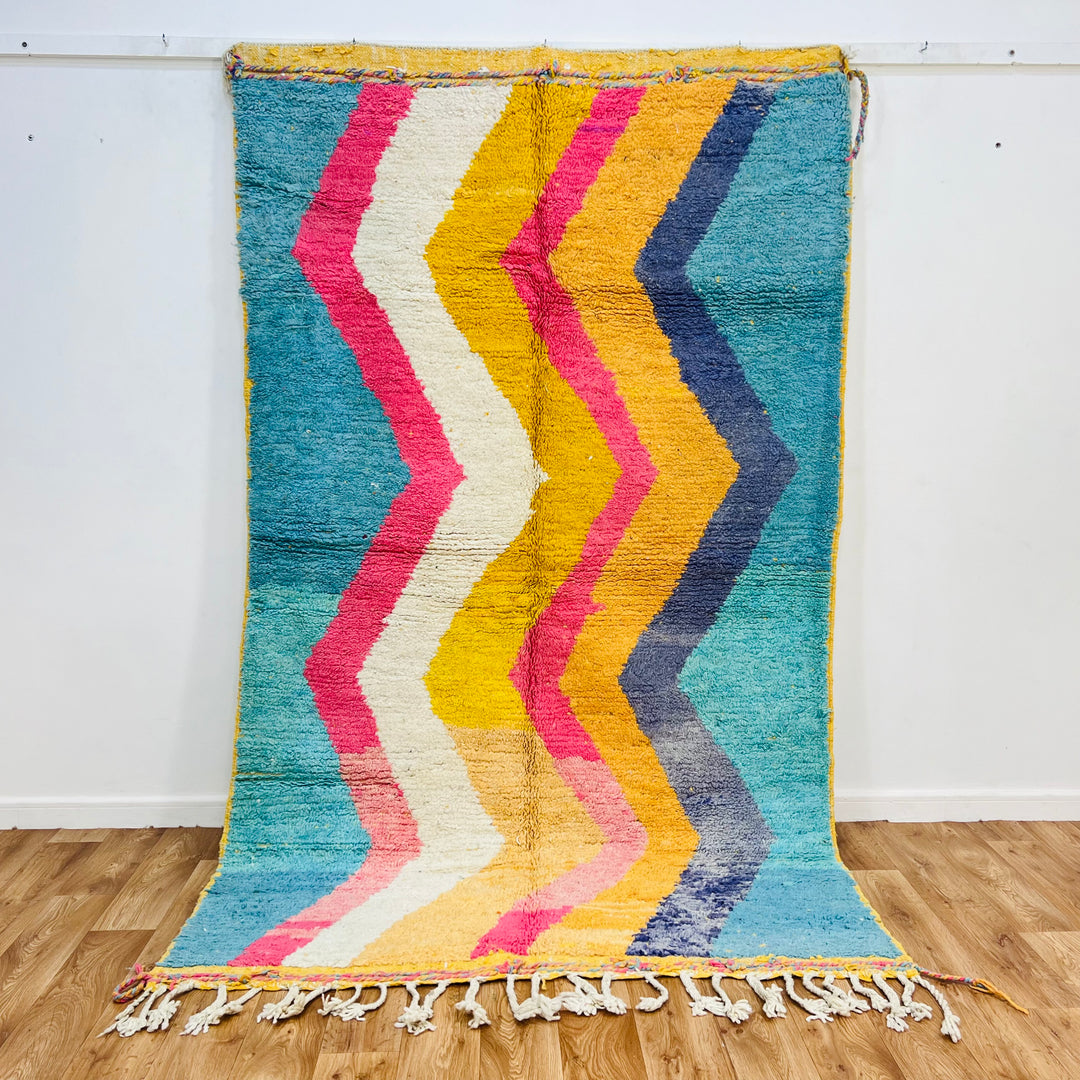 Vintage Moroccan rug with colorful zigzag patterns, handmade from wool, 258x152 cm, featuring pink, turquoise, mustard, and navy shades.