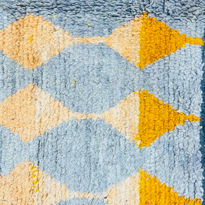 Close-up of Vintage Moroccan Rug 564 with orange and yellow diamond motifs on a grey background, 255 x 158 cm, 100% wool.
