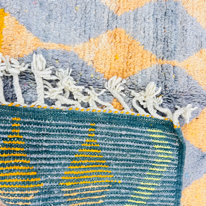 Vintage Moroccan rug with grey, orange diamond pattern and fringe, handwoven wool. Ideal for modern or eclectic spaces.