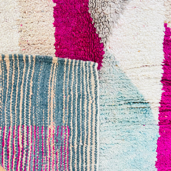 Vintage Moroccan rug with abstract pink, beige, navy, and grey shapes. Medium-thick wool texture showcasing Berber artistic design.