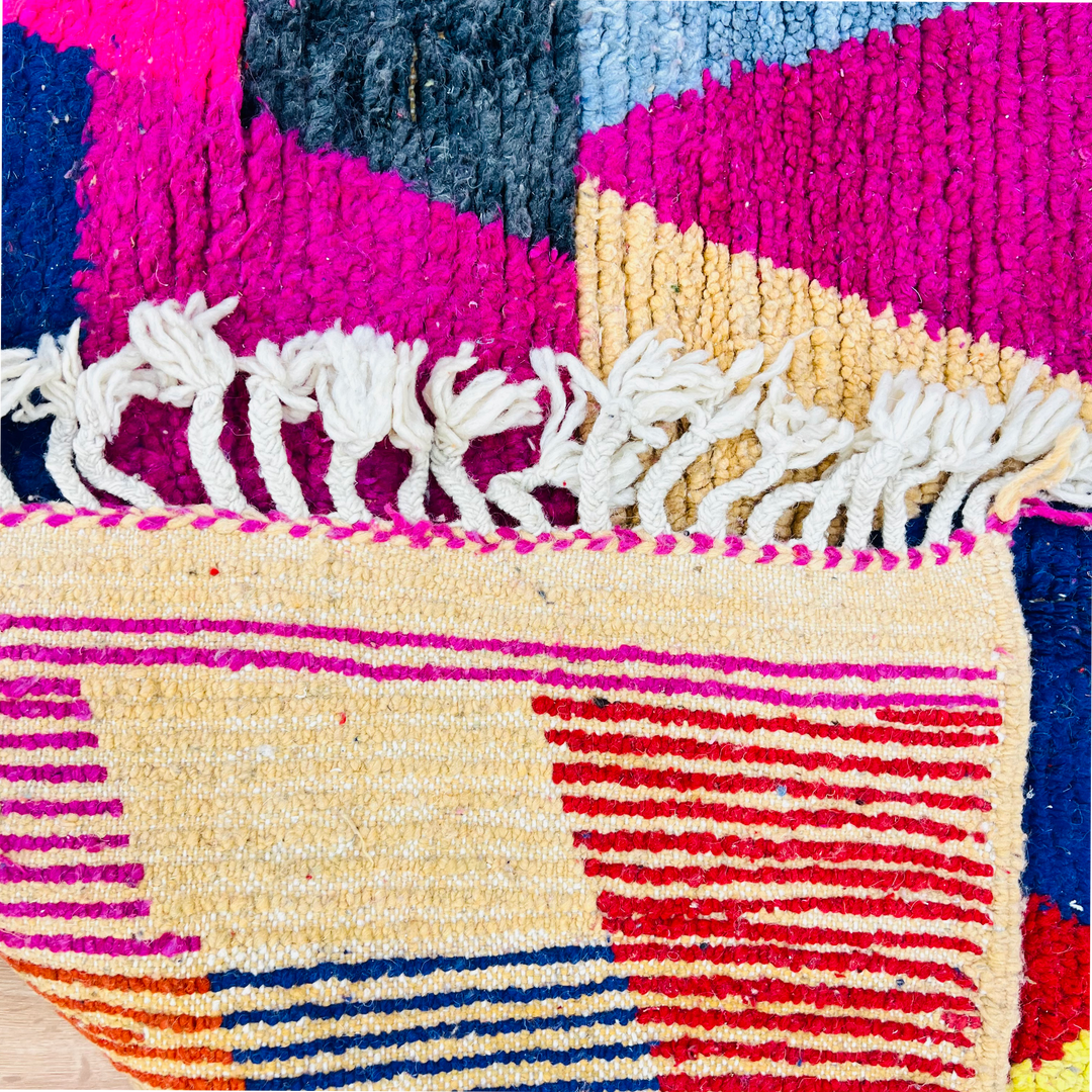 Vintage colorful Moroccan rug with geometric patterns in pink, yellow, and blue. 255 x 150 cm, wool, Berber symbolism.