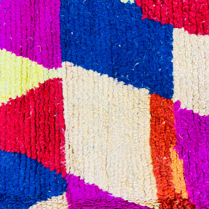 Colorful vintage Moroccan rug with geometric patterns in pink, blue, red, yellow; handwoven wool, traditional Berber style.