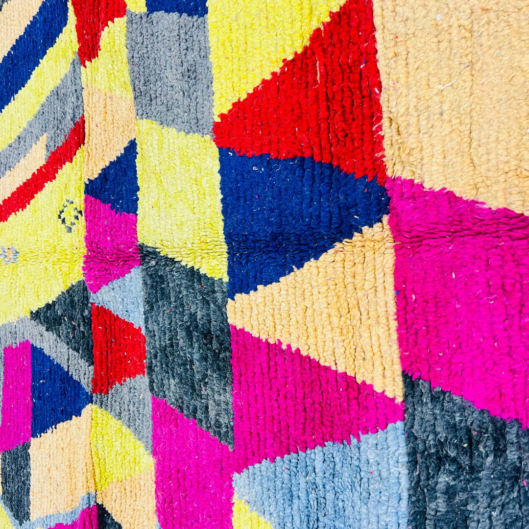 Vintage Moroccan rug with colorful geometric patterns in pink, yellow, red, and blue, 255 x 150 cm, handwoven in wool.
